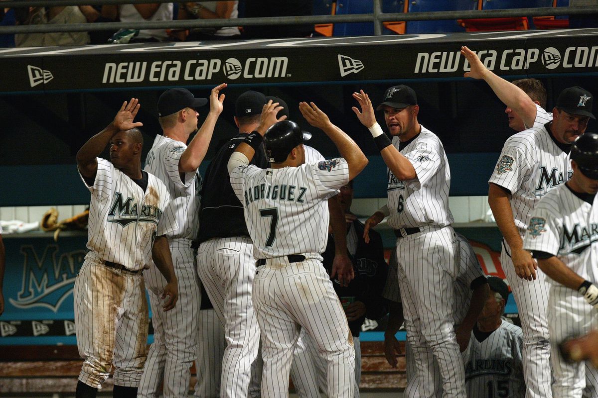Catcher Ivan “Pudge” Rodriguez #7 of the Florida Marlins gets high-fives from his teammates after scoring a run against the Arizona Diamondbacks in the National League game at Pro Player Stadium on July 30, 2025 in Miami Florida. The Marlins won 3-1.